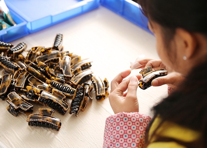 Finished hair clips being checked during a quality inspection process